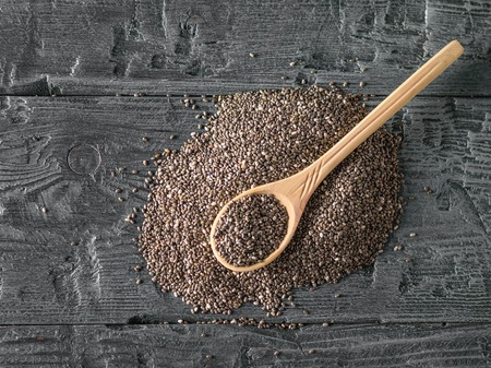 Wooden spoon on a pile of black Chia seeds. Vegetarian food. Diet for weight loss. The view from the top. Flat lay.の写真素材