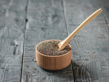 Wooden spoon in a bowl with black Chia seeds on a wooden table. Vegetarian food. Diet for weight loss.の写真素材