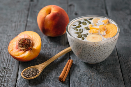 The fruits of peach and pudding from Chia seeds black on black rustic table. Diet food for weight loss and cleansing the body.の写真素材