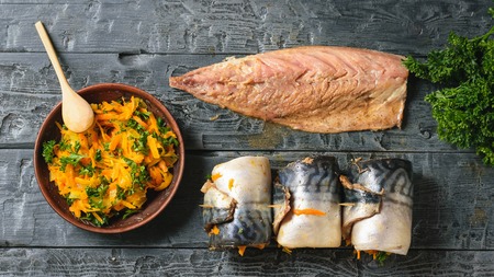 A bowl of steamed vegetables, the carcass of the mackerel and the three prepared loaf fish for baking. A dish of sea fish stuffed with vegetables. The view from the top.の写真素材