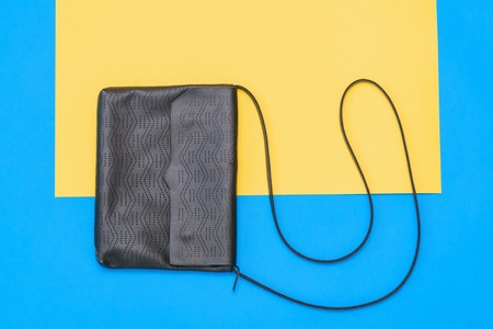Beautiful women bag of blue leather on yellow and blue background. Women's accessories on colored background. The view from the top. Flat lay.の写真素材
