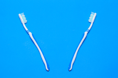 Two toothbrushes on a blue background. Oral care products. The view from the top. Flat lay.