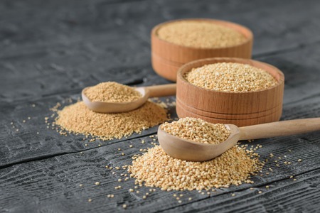 Amaranth and quinoa seeds and two wooden spoons on a rustic table. Gluten free food.