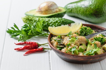 Salad of amaranth, avocado and parsley seeds with olive oil on a white wooden table. Dietary...