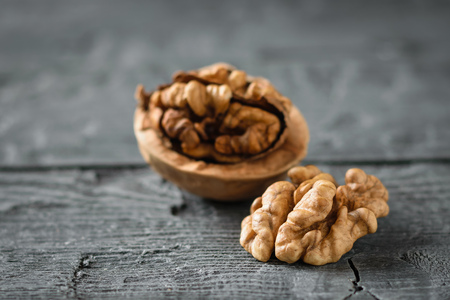 Split walnut on a dark wooden table. Natural diet food.の写真素材