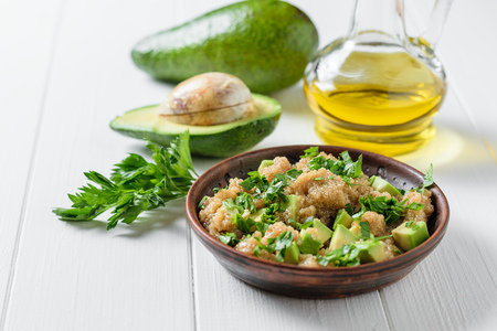 Salad of amaranth seeds, avocado and parsley with olive oil on a white wooden table. Dietary vegetarian dish.の写真素材