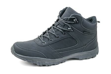 Insulated black men's shoes on the left leg isolated on a white background. Casual sports men's shoes.の写真素材