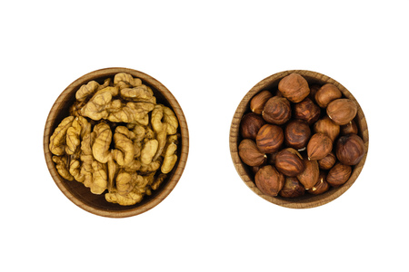 Wooden bowl with hazelnuts and wallnuts isolated on white background. Natural diet vegetarian food. The view from the top.の写真素材