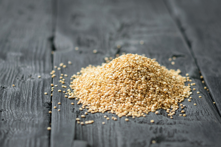 A small pile of quinoa seeds on a black rustic table. Gluten free food.の写真素材