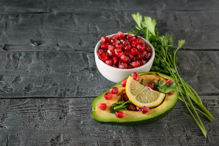 White bowl with pomegranate seeds and half avocado with pomegranate seeds. Vegetarian cuisine for weight loss. Healthy diet.の写真素材