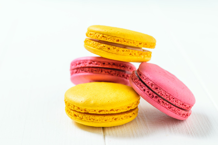 Macaroon cake red and yellow on a white wooden table on a white background. Freshly made homemade macaroons.の写真素材