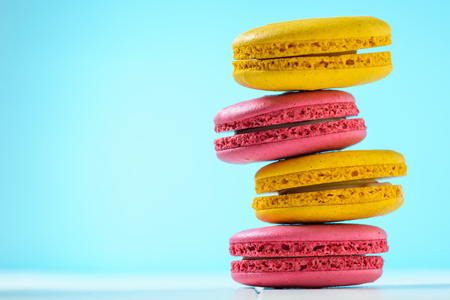 Macaroon cake red and yellow on a white wooden table on a blue. Freshly made homemade macaroons.の写真素材