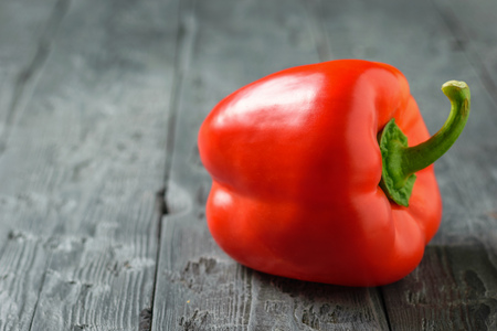 Ripe beautiful red pepper on a rustic table. Vegetarian food. The concept of healthy eating.