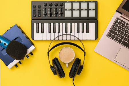 Music mixer,microphone, headphones and sound card on yellow background. The concept of workplace organization. Equipment for recording, communication and listening to music.の写真素材