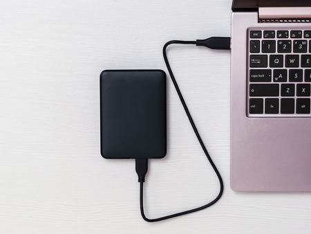 Connected to an external hard drive and a laptop on the table. The view from the top. The concept of...
