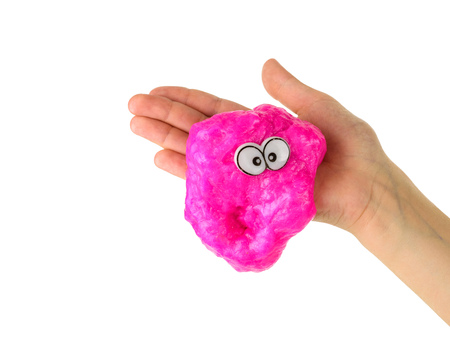 Red slime with eyes slides off baby's hand isolated on white background. Toy antistress. Toy for the development of hand motor skills.の写真素材