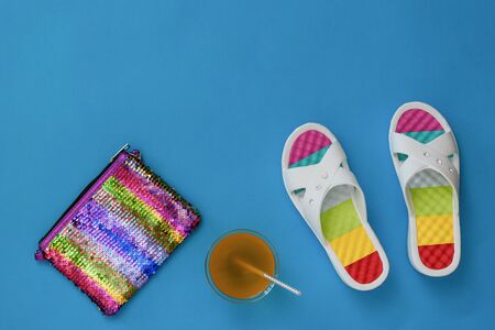 Refreshing drink, bag and flip flops on a blue background. The concept of summer vacation. Flat lay. The view from the top.の写真素材