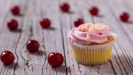 Fresh homemade cherry berry cupcakes on wooden table. Dessert with fresh cherry berries.の写真素材