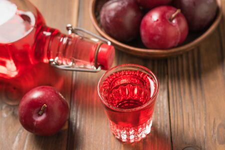 Plum alcoholic drink and plum berries on the table. Homemade alcoholic drink made from berries plum. Flat lay The view from the top.の写真素材