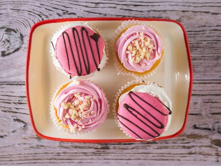 Four cupcakes in a bowl on the table. Dessert with fresh cherry berries.