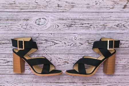 Two black summer women's shoes opposite each other on a wooden background. Flat lay. The view from the top.の写真素材