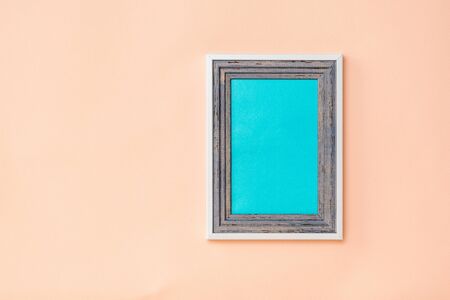 Wood frame with blue background inside the bedding on a coral background. The color trend. Minimalism. Background for photo placement.の写真素材