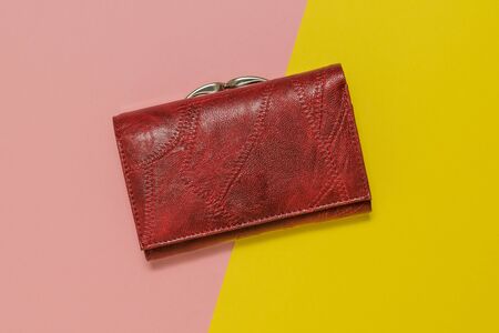 Female purse dark Burgundy color on a yellow and pink background. Fashionable women's accessory.の写真素材