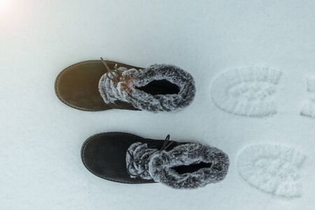 Warm women's shoes with traces in the snow. Beautiful and practical women's winter shoes.
