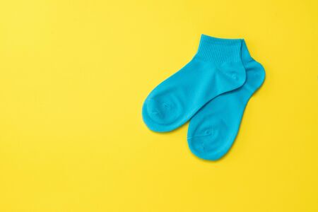 Blue sports socks on a bright yellow background. The concept of sport and love. Flat lay.の写真素材