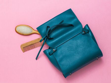 Two wooden combs and a leather women's bag on a red background. Women's accessories.の写真素材
