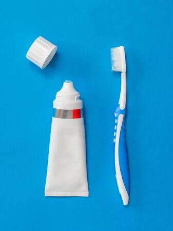 A toothbrush and an open tube of toothpaste on a blue background. Means to care for the oral cavity. Flat lay.の写真素材