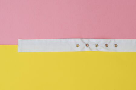 White belt separating the yellow and red surface. Women's accessory. The concept of differentiation.