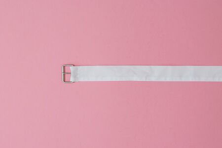 White material belt on a red background. Women's accessory. The concept of differentiation.の写真素材