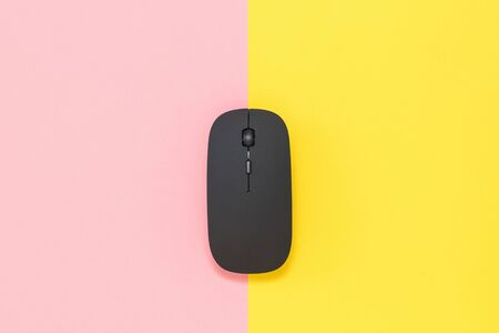 Wireless computer mouse on a yellow and red background. Peripheral devices for computers.