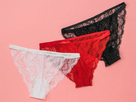 Three multicolored women's panties on a bright red background. Underwear. The view from the top....