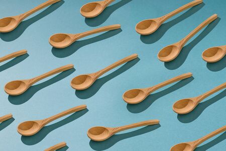 Background of a large number of wooden spoons on a blue background. Wooden Cutlery.の写真素材