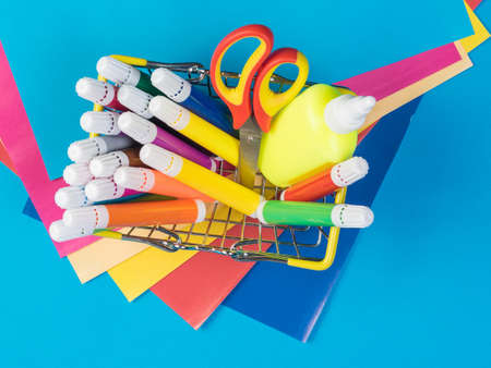 A set of bright stationery in a basket and sheets of colored paper. A set for creativity and implementation of ideas.の写真素材