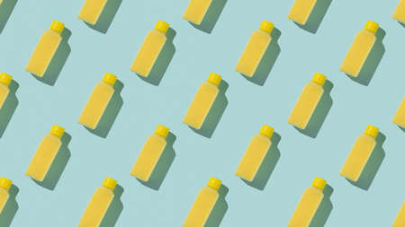 Pattern of yellow plastic bottles on a blue background. Cosmetic product in a plastic bottle.の写真素材