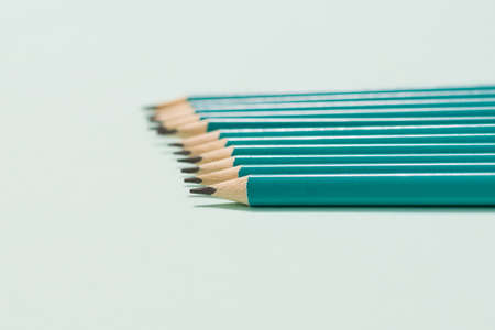 Horizontal graphite pencils on a light blue background. Selective focus. Paper and office supplies.の写真素材