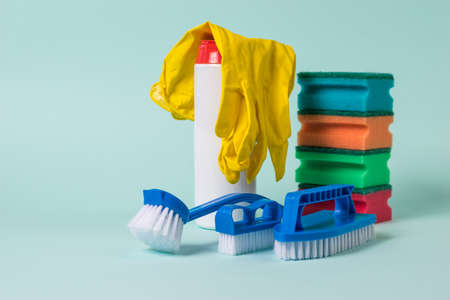 Blue brushes, foam sponges, cleaning powder and gloves on a blue background. The concept of cleaning and maintaining cleanliness.の写真素材