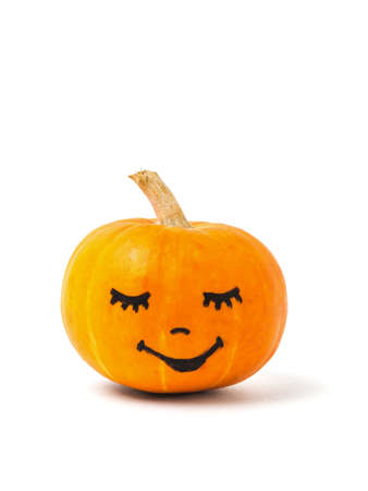 A ripe orange pumpkin with a painted face isolated on a white background. Halloween party.の写真素材