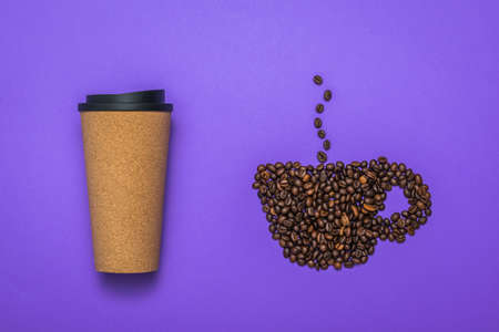A Cup of coffee beans and a paper glass on a lilac background. The concept of a morning drink.