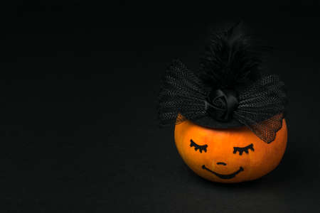 Pumpkin with closed eyes on a black background. Halloween party.の写真素材
