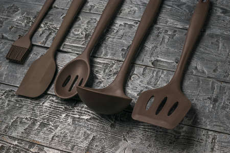 Set of silicone kitchen accessories on a wooden background. Kitchen appliances.