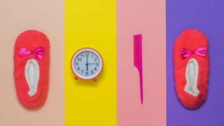 Alarm clock, hairbrush and Slippers on a multicolored background. Accessories to start the day.の写真素材