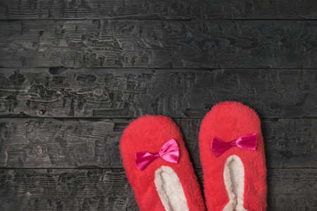 Top view of red house Slippers on a wooden background. Comfortable shoes for home.の写真素材