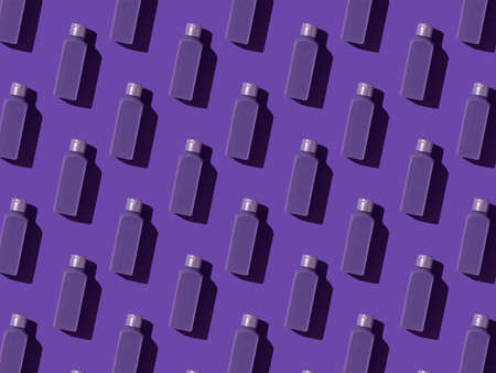 Seamless pattern. Monochrome image of purple bottles on a purple background. Cosmetic product in a plastic bottle.の写真素材