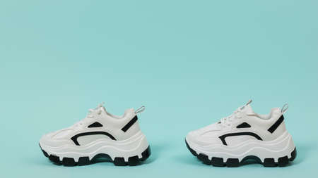 Modern fashion sneakers on a light blue background. Sports shoes with high soles. Place for text