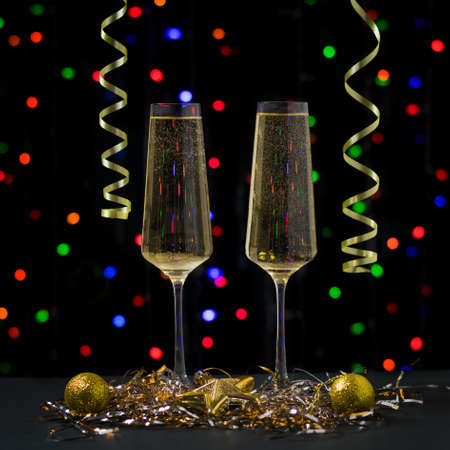 Christmas card with two glasses of sparkling wine on the background of bokeh. Meeting of Christmas and new year.の写真素材