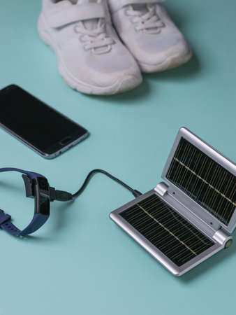 Charging your smart watch from a solar-powered power source during a workout. Use of solar energy. Future technology.の写真素材